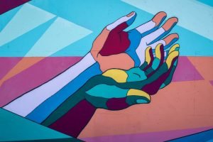 Illustration of two colourful hands in various colours